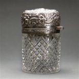 Sterling silver mounted cut crystal vanity jar, the mounted hinged lid with a floral repousse motif,