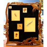Framed art work, the shaped frame having a metallic finish, surrounding birds, floral and jewelry