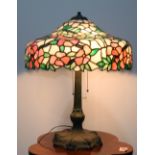 Arts and Crafts leaded glass table lamp, having a floral decorated shade above the three light