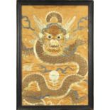 Chinese embroidered fragment, gilt couched with a front facing dragon on a tan colored ground,