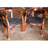 Pair of French Empire Mahogany armchairs, having a barrel back, with ormolu mounts, and rising on (