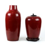 (lot of 2) Chinese ox blood glazed porcelain: first a tapering ovoid jar, with wood lid and stand;