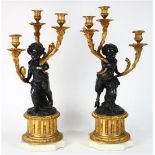 Pair of Continental Louis XV style gilt and patinated bronze candelabra after Clodion, each having