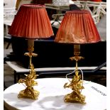 Pair of Rococo style table lamps, each having a single light above a figural standard of a putto,