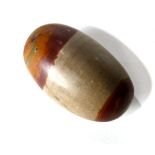 Shiva Linga, the conical egg shape having a buff colored fine grain with natural red markings to the