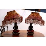 Pair of patinated metal figural blackamoor lamps, each depicted seated and holding the single