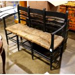 Shaker style three seat bench, having a painted black frame and rush seat, 3'h x 4'3''w x 12'4''d