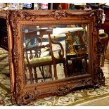 Victorian closed corner looking glass, having a bevelled mirror with a bronzed molding having scroll