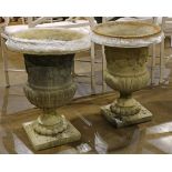 Pair of Classical style cast garden urns, each having an urn form and rising on a rectangular