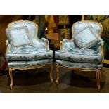 Pair of Louis XV style bergeres, each having silk floral fabric and rising on carved cabriole