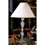 French silhouette metal table lamp, having a half shade above a single light, continuing to the