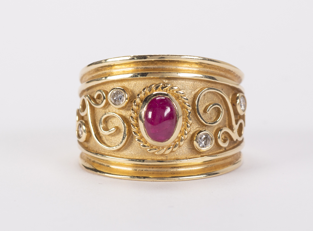 Ruby, diamond and 14k yellow gold ring Featuring (1) oval ruby cabochon, accented by (4) full-cut