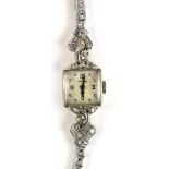 Lady's diamond and 14k white gold wristwatch Dial: square, off white, applied dot and black Arabic