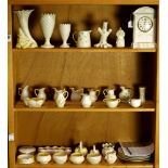 Three shelves of Belleek, including vases and creamers, etc., with various date marks including