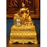 French ormolu mantle clock circa 1860, having a female reserve leaning against the brass dial having