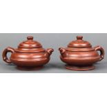 Pair of Chinese zisha teapots, with a compressed body with raised bands, with faux bamboo handle and