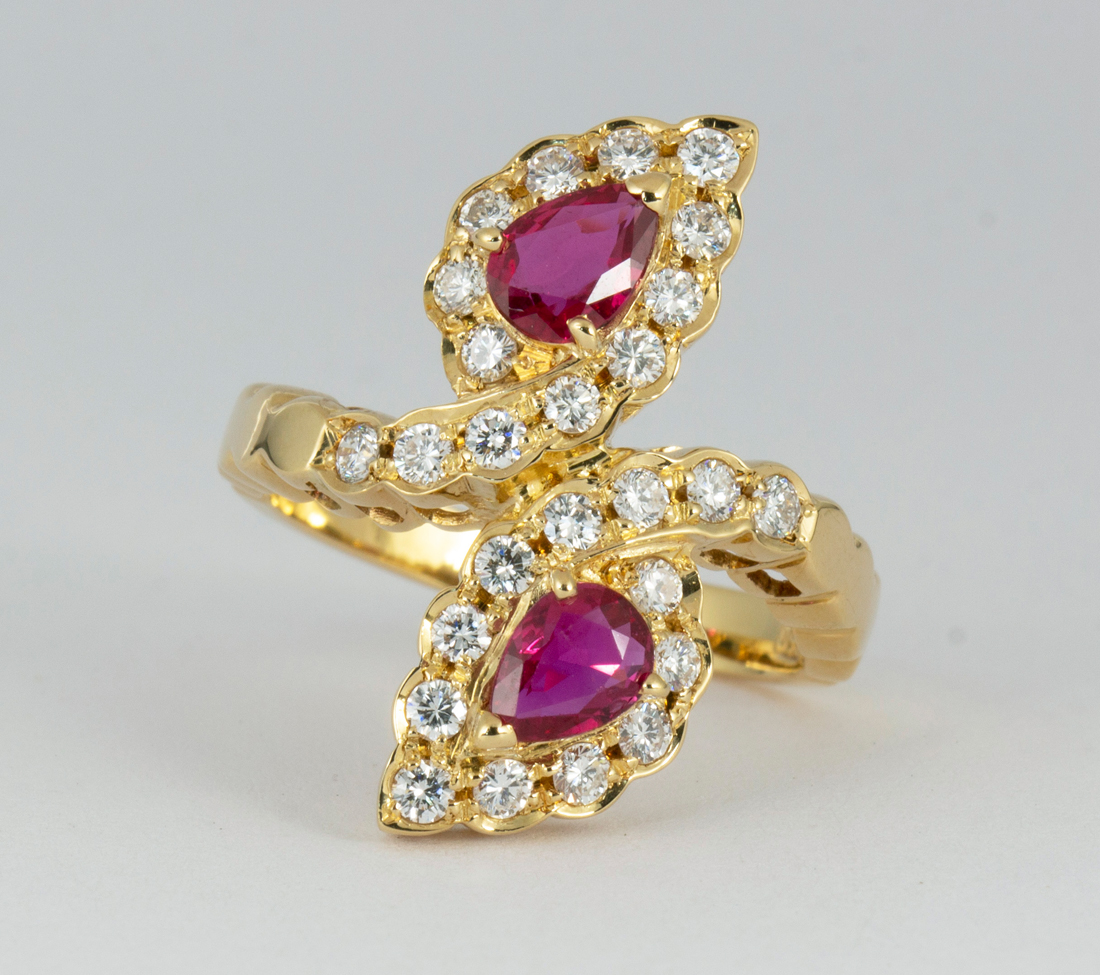 Ruby, diamond and 18k yellow gold ring Featuring (2) pear-cut rubies, weighing a total of