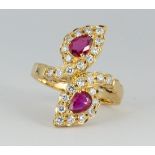 Ruby, diamond and 18k yellow gold ring Featuring (2) pear-cut rubies, weighing a total of