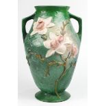 Roseville pottery jardiniere, having a tapered form with handled sides, the body accented with