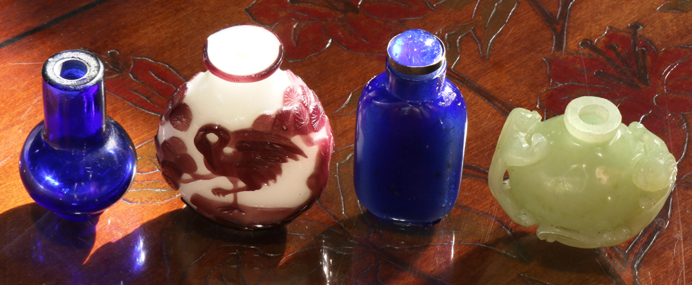 Chinese four snuff bottles: two blue glass bottles, an aubergine overlaid white vessel with deer;