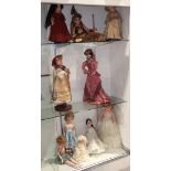 Three shelves of composition and porcelain dolls, including a Victorian style doll, marked "hand