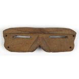 Eskimo snow goggles, executed in carved wood with slits for eyes, 1.5"h x 5"w