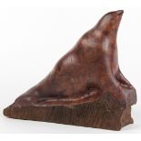 Carved burl sculpture, in the form of a stylized sea lion, underside marked "Youth vs. Maturity,