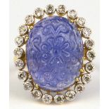 Tanzanite, diamond and 18k yellow gold ring Centering (1) carved oval tanzanite cabochon,