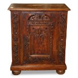 Continental oak commodino, having a rectangular top above a highly carved door, flanked with