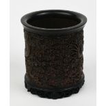 Chinese bamboo and wood brush pot, the cylindrical body featuring a meandering dragon amid dense