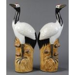 Pair of Chinese porcelain cranes, each standing on a rocky plinth accented by lingzhi, the base
