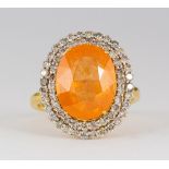 Garnet, diamond and 18k yellow gold ring Centering (1) oval-cut spessartine garnet, weighing