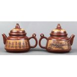 Pair of Chinese zisha lidded teapots, of conical form inset with a tan colored landscape panel