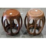Pair of Chinese wooden barrel stools, with a circular floating top panel, above bulging supports