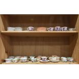 Two shelves of assorted porcelain and transferware tea cups, including Mason's Vista, Dresden, etc.