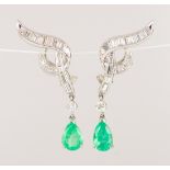 Pair of emerald, diamond and 18k white gold earrings Featuring (2) pear-cut emeralds, weighing a