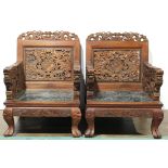 Pair of Chinese dragon armchairs, the back, arms and apron elaborately carved with meandering