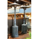Classical style outdoor space heaters, each having a domed shade above a baluster standard,