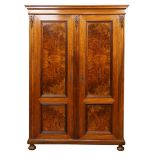 English walnut wardrobe circa 1900, having burl panelled doors and rising on compressed bun feet,