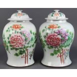 Pair of Chinese enameled porcelain lidded jars, decorated with peonies accented by leafy branches,