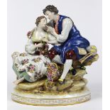 Continental porcelain sculpture depicting a courting couple, depicted seated on a rock form, the