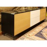 Contemporary mixed wood sideboard, having an ebonized case with blonde doors flanking the