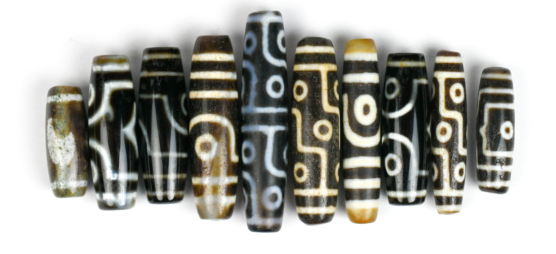 (lot of 10) Tianzhu/Dzi-style beads, mostly of cylindrical form with 'eyes', largest; 2.75"w