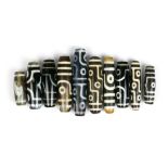 (lot of 10) Tianzhu/Dzi-style beads, mostly of cylindrical form with 'eyes', largest; 2.75"w
