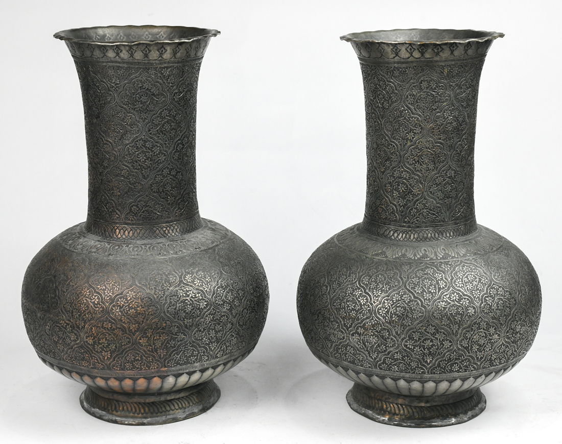 Pair of Middle Eastern silvered copper vases, each having a stick neck above a bulbous body,