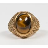 Tiger's eye and 10k yellow gold ring Featuring (1) oval tiger's eye cabochon, measuring