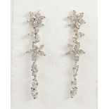 Pair of diamond and 18k white gold earrings Designed as articulated linked flower motifs,