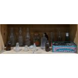 One shelf of vintage glass bottles in clear and brown, together with marbles, etc.