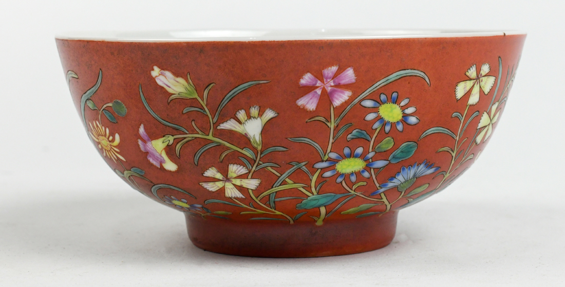 Chinese enameled porcelain bowl, featuring various flowers on an orange ground, base with apocryphal