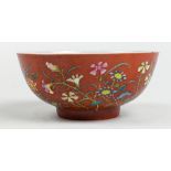 Chinese enameled porcelain bowl, featuring various flowers on an orange ground, base with apocryphal